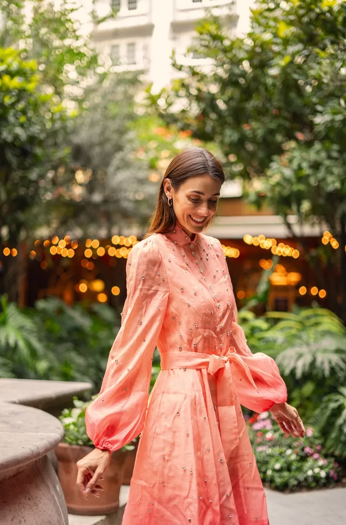 Vestido corto con efecto ombré, manga larga abullonada, botones joya al frente y aplicaciones brillantes. Disponible en rosa/naranja y verde/azul. El look perfecto para brillar este verano.