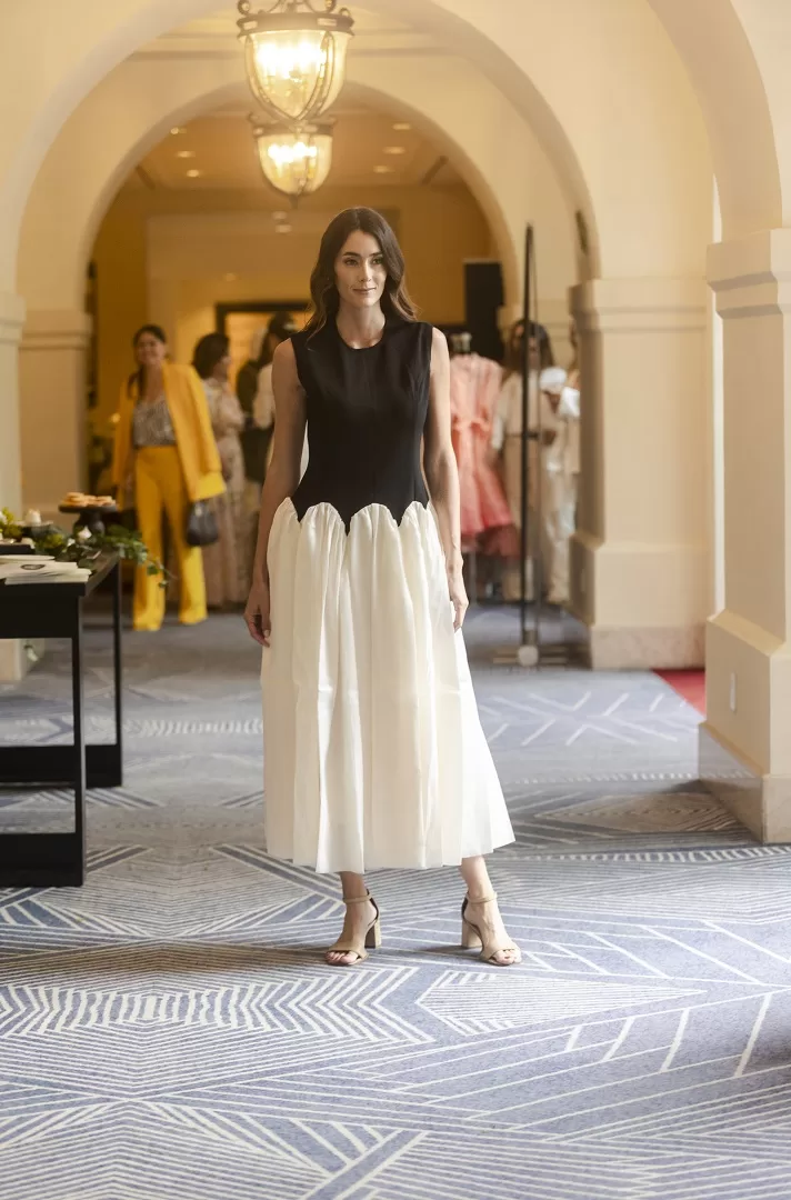 Vestido bicolor blanco con negro de corte maxi-midi, con corset liso sin mangas y falda amplia con ondas estructuradas. Una silueta escultural y elegante que fusiona lo clásico con lo moderno.