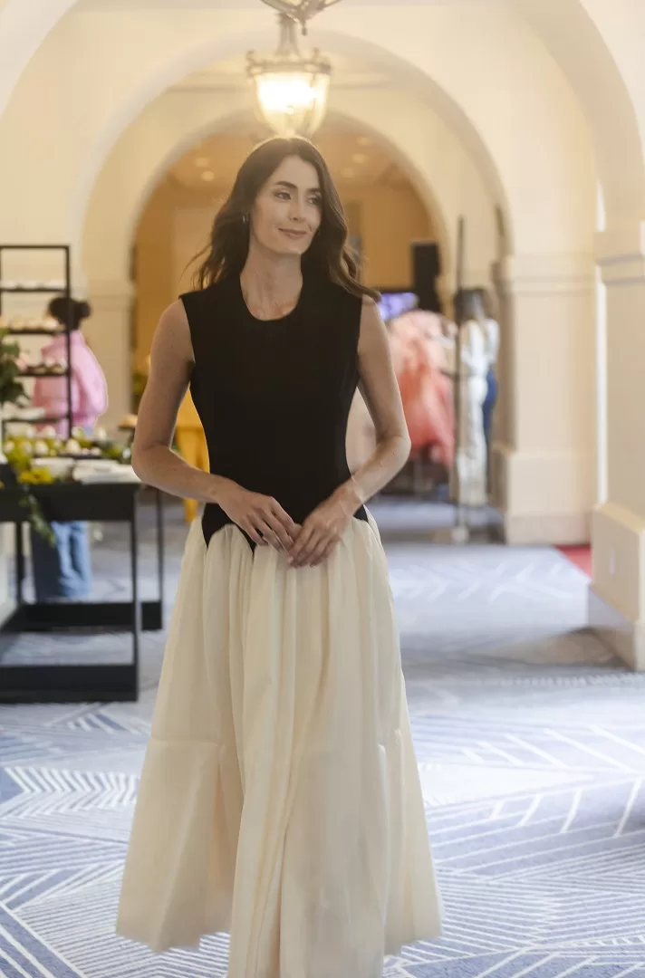 Vestido bicolor blanco con negro de corte maxi-midi, con corset liso sin mangas y falda amplia con ondas estructuradas. Una silueta escultural y elegante que fusiona lo clásico con lo moderno.