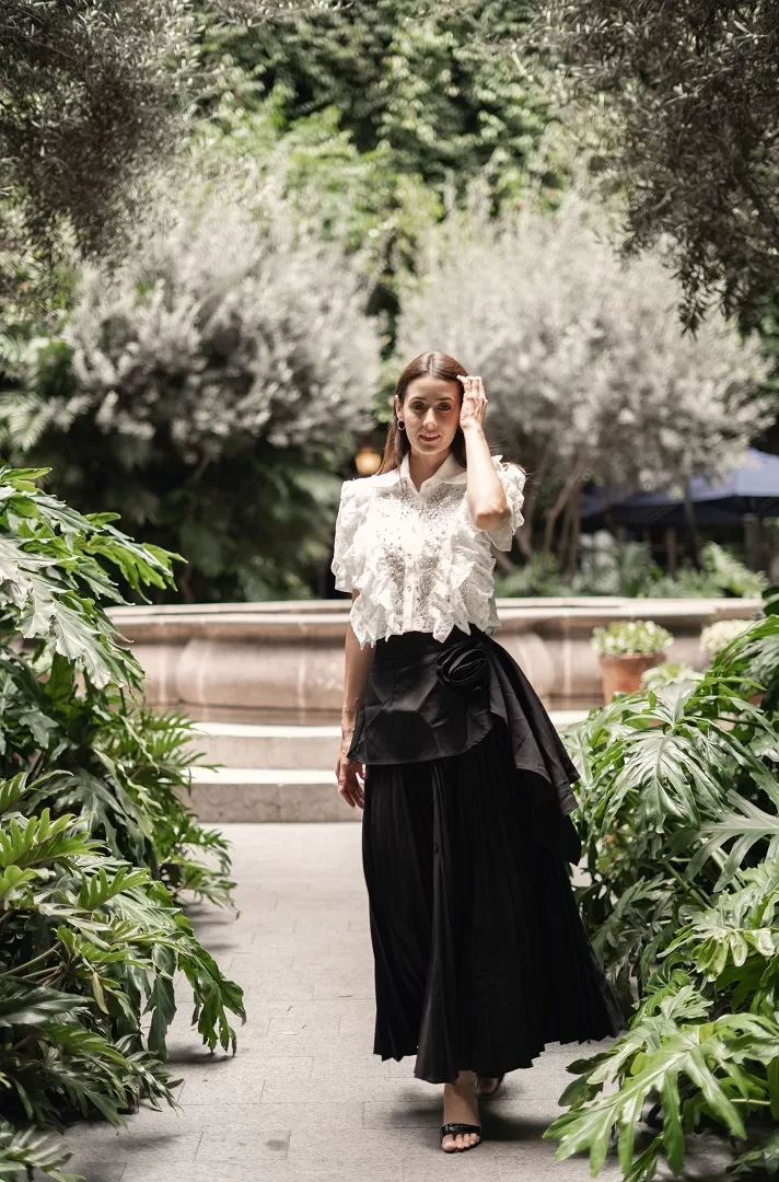 Maxi falda negra plisada con detalle de flor drapeada. Una pieza elegante y atemporal que combina estructura, feminidad y movimiento.