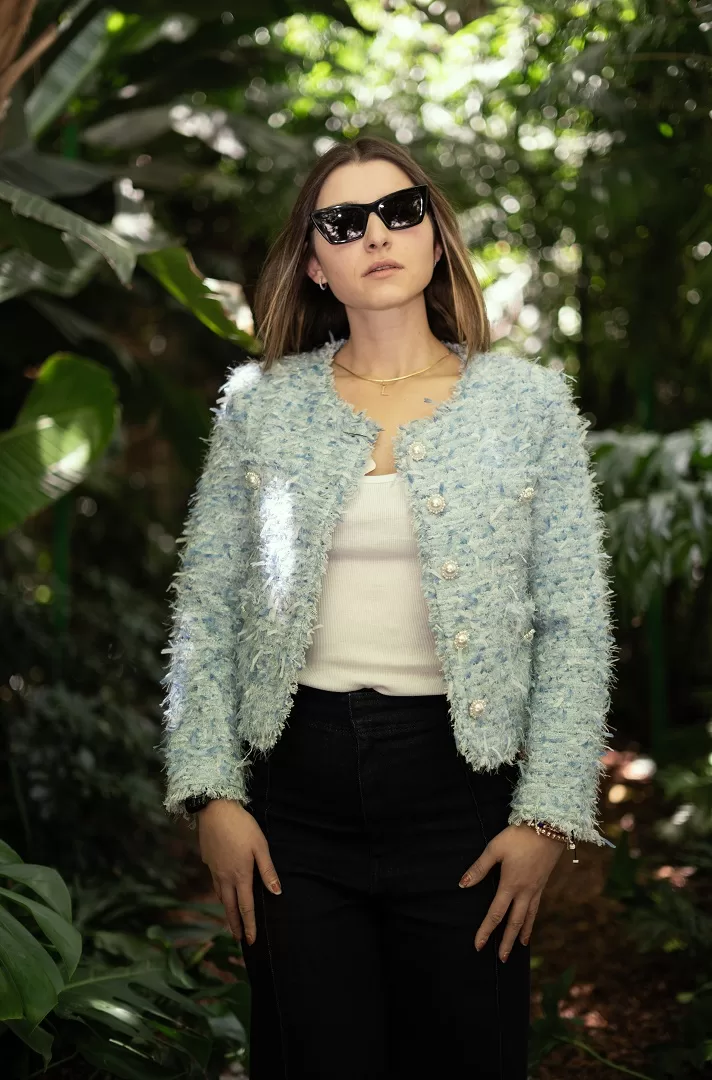 Saco azul claro tipo Chanel con textura bouclé y botones joya con perla. Un básico elevado para primavera-verano que combina elegancia y frescura.