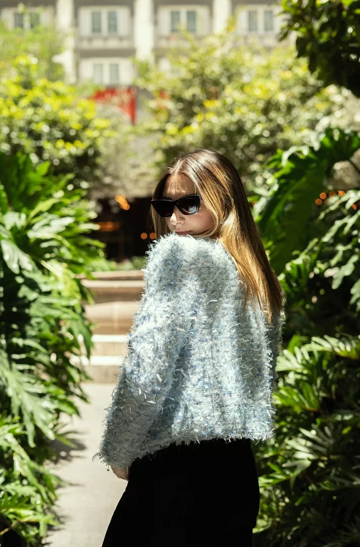 Saco azul claro tipo Chanel con textura bouclé y botones joya con perla. Un básico elevado para primavera-verano que combina elegancia y frescura.